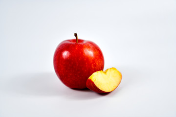 Red apple and slice on a white background.