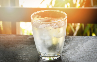 A glass of water with ice cubes in glass on the table