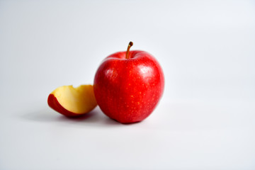 Red apple and slice on a white background.