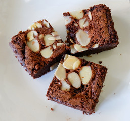 brownies cake on plate / piece of chocolate cake cocoa with nut on top view brownies slice on white...