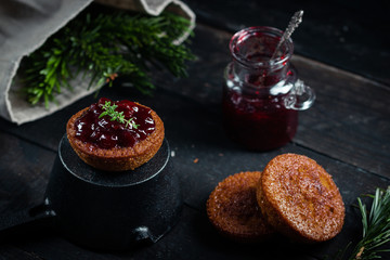 Little chocolate homemade muffin garnished with cherry jam. Dark moody style. Selective focus