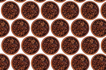 Brown raisins in a wooden cedar plate on a white isolated background. Row of bowls with brown raisins, top view. Brown raisins pattern