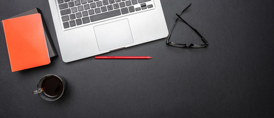 Computer laptop and mobile phone on black color office desk, banner