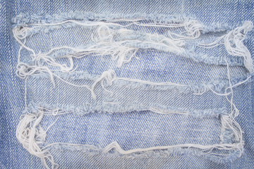 Blue jeans with ripped patterns for background, hole and white threads destroyed on denim