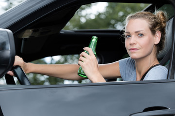 female driver drinking beer