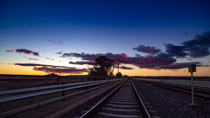 Fototapeta na wymiar Evening and vivid sunset on the railroad tracks