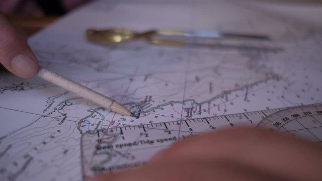 Man hands with pencil and ruler on  sea map chooses a route&nbsp;