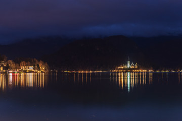 Fototapeta na wymiar Night on Lake Bled. Christmas atmosphere and lights. Castle and Church of the Annunciation