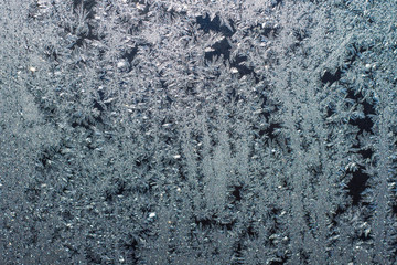 Ice patterns on glass, frost on a winter window, fancy patterns of winter.