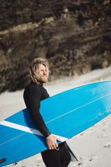 surfer with flippers and a bodyboard in a hydro suit on the ocean shore