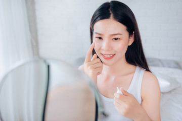 Beauty Asian Woman use Acne Gel Skincare after Cleansing on Face His Happiness and Look at mirror...
