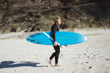 surfer with flippers and a bodyboard in a hydro suit on the ocean shore