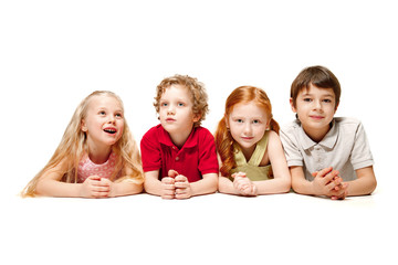 Close-up of happy children lying on floor in studio and looking up, isolated on white background. Kids emotions, Day of book, education, school, kid, knowledge, childhood, friendship, study concept
