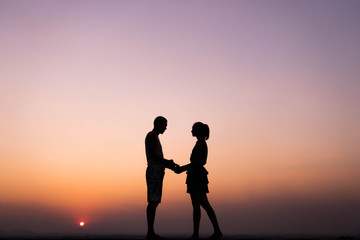 Fototapeta na wymiar silhouette of couple holding hand at sunset
