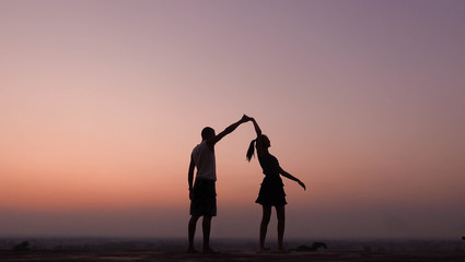 silhouette of couple dancing at sunset