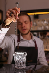 Professional bartender prepairing orange cocktail 