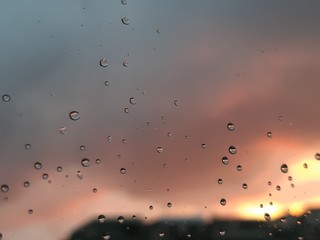 Genova, Italy - 01/17/2019: Beautiful caption of the sunset over the city of Genova by day after a huge rain in winter days with some waterdrops over the window. 