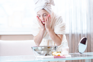 Beautiful young woman washing face with water in the morning. Concept of hygiene and care for the...