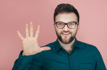 a man with a beard in glasses and a shirt shows five on his fingers