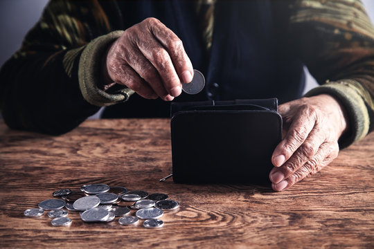 Elderly woman putting coin to wallet.