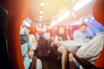 Salon of public transport bus or train with passengers, blurred background