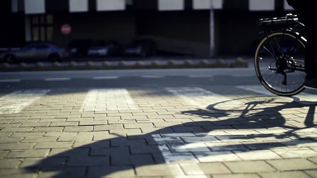Midsection of male cyclist cycling on an electrobike in city. Slow motion.