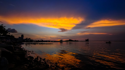 Dramatic sunset sky at sea with silhouette of island background