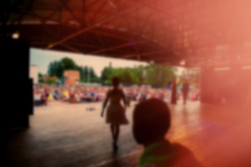 musician performs a rock band concert in the evening in the open air and fans.