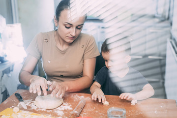 Fototapeta na wymiar mom and son cook dough and flour fun dirty in the kitchen