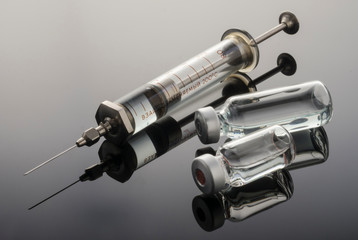 Vintage syringe with vials, conceptual image