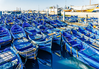 Fototapeta na wymiar Essaouira, Morocco. Blue fishing boats in the ancient and old fishing port