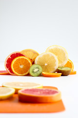 Layers of sliced fruits - kiwi, orange and grapefruits, with first plan