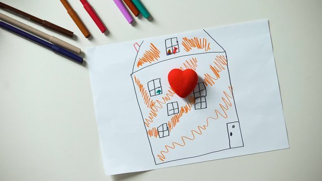 Kid putting heart figure on house painting, looking for home and family, orphan