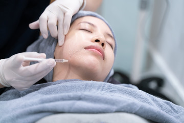 Obraz na płótnie Canvas Needle mesotherapy in beauty clinic. Cosmetics injected to woman's face.