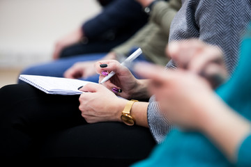 Businessman writing on notepad during a meeting, closeup
