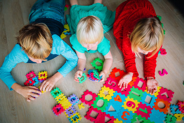 kids playing with number and shapes puzzle