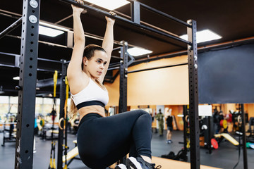 Strong athletic young champion woman works with her own weight on the bar. The concept of building a slim body