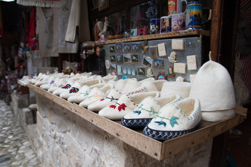 Kruje, Albania - June 2018: Traditional Ottoman market in Kruja, birth town of National Hero Skanderbeg. Flea market in Albania. Wool craft souvenirs for sale.