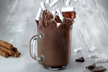 Cocoa splash made by dropped marshmellow in a transparent glass.