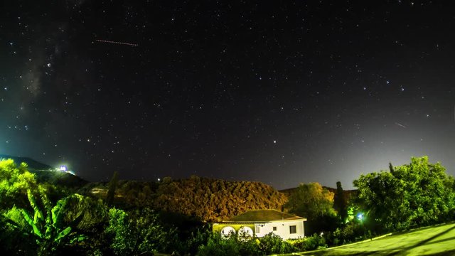 TIMELAPSE: Night landscape. Night sky with a north hemisphere Milky Way and stars. Star trail on island Crete