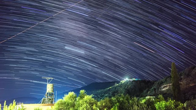 TIMELAPSE: Night landscape. Night sky with a north hemisphere Milky Way and stars. Star trail on island Crete