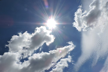 The Sun and white clouds in the blue sky