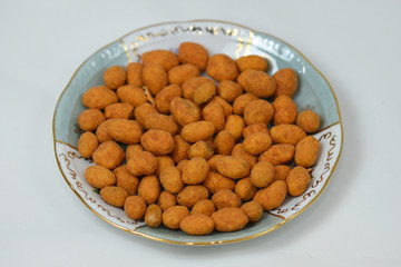  peanuts roasted in a spicy coat  on a porcelain plate