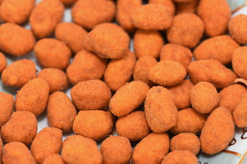  peanuts roasted in a spicy coat  on a porcelain plate