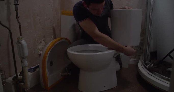 Plumber installing a new toilet in a bathroom
