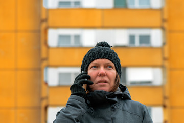 Woman talking on mobile phone on street in winter