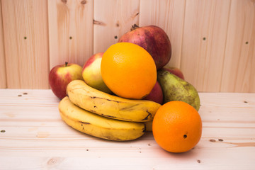 Various fruits apples, bananas, oranges, pomegranates on natural wooden background. Healthy food