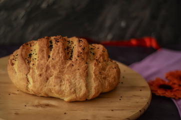 Handmade loaf bread on wooden table and on dark background