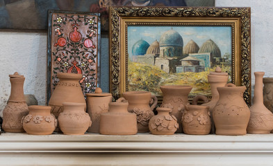 Fototapeta na wymiar row clay pots on the background of paintings. children's crafts
