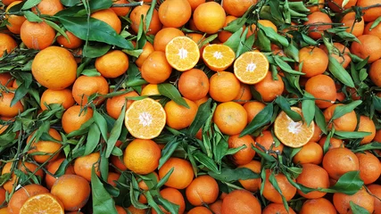 Zelfklevend Fotobehang Orange fruit with leaves for sale on market © Balint Radu